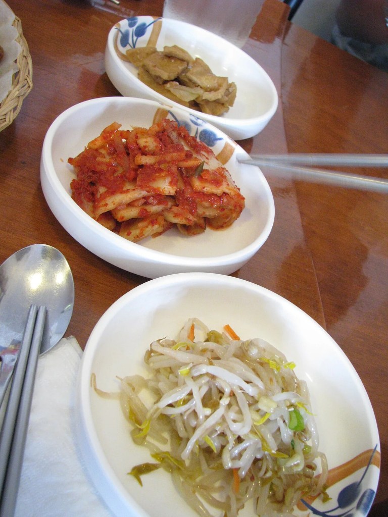 Fresh Korean kimchi and seasoned bean sprouts, the refillable banchan staples — banchan korean side