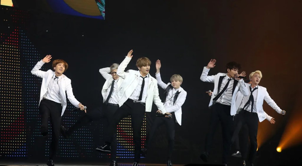 BTS performing on stage in white suits at KCON, the group whose members each have a favorite Korean dish — bts favorite korean