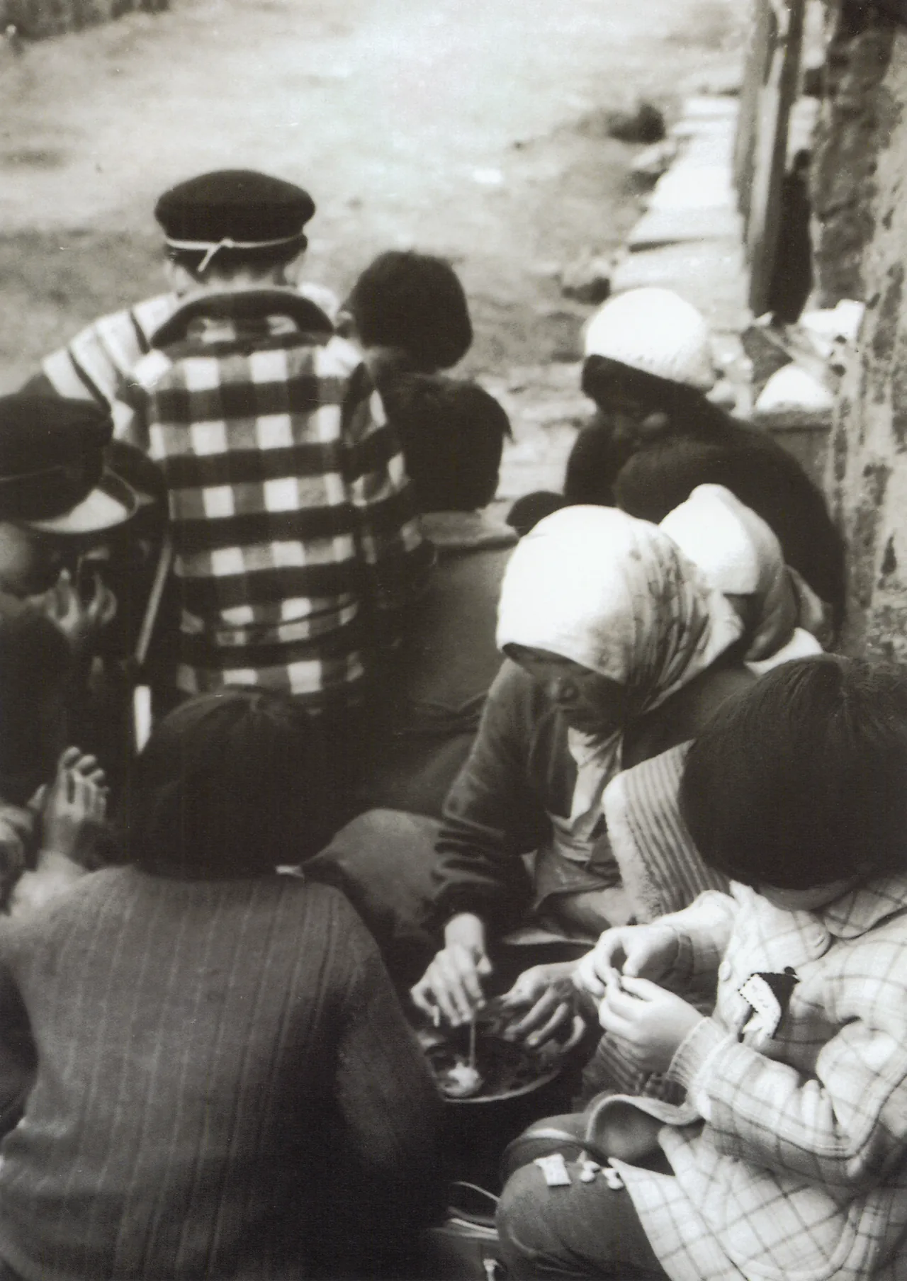 Vintage photo of Korean children gathered around a street vendor playing the sugar-candy shape game — squid game dalgona