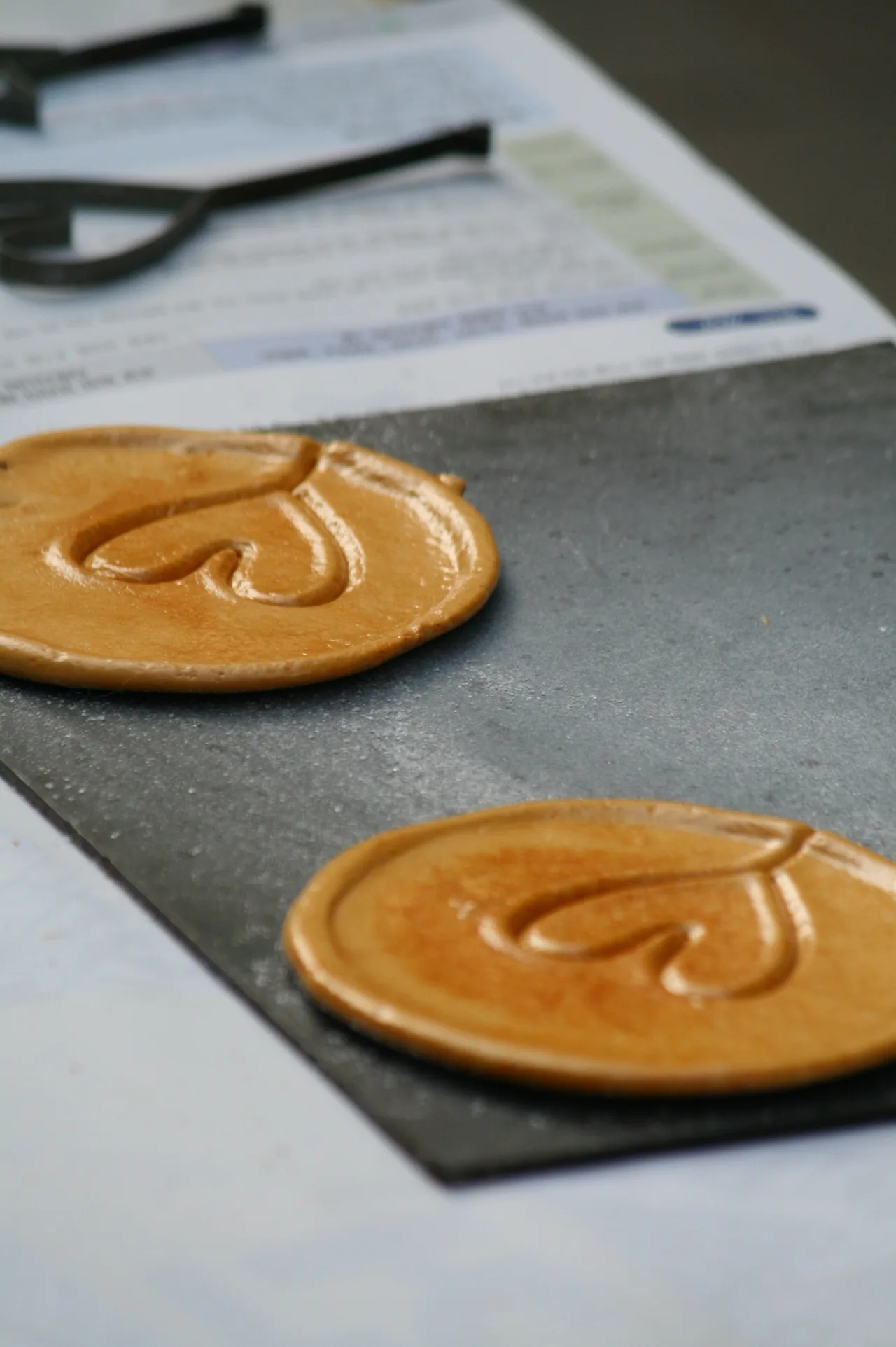 Close-up of a real dalgona honeycomb sugar candy disc, golden and brittle — squid game dalgona