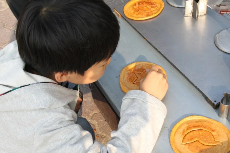 A plate of real Korean dalgona candy on sticks — squid game dalgona