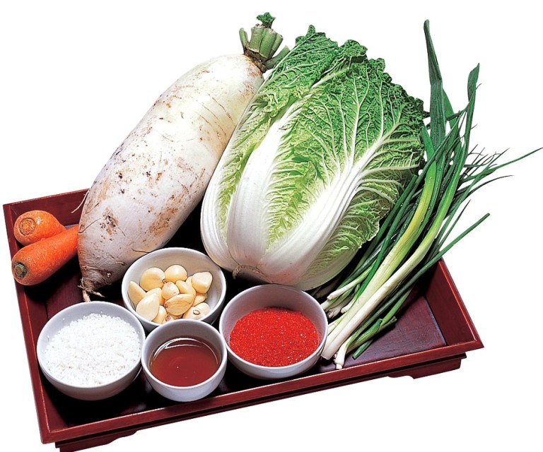 Kimjang, the Korean tradition of making kimchi together, people preparing cabbage — kimchi white chili
