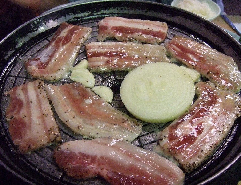 Korean BBQ pork belly grilling over charcoal at a Korean barbecue table — korean bbq sejong
