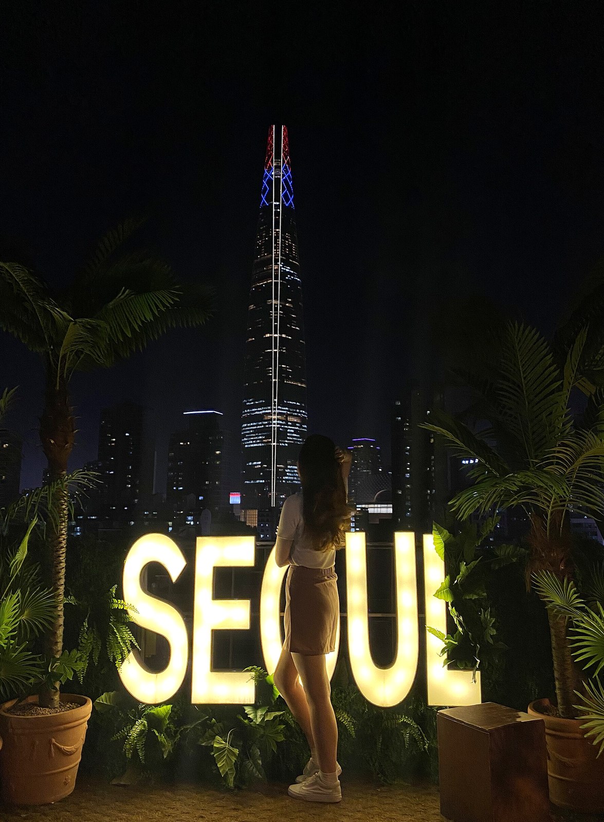A rooftop cafe photo zone in Seoul at night with a lit SEOUL sign and city skyline — korean coffee king