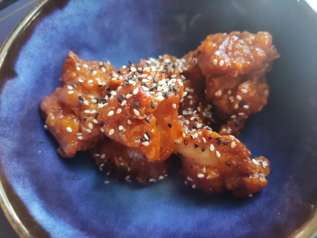 Korean fried chicken glazed in glossy sweet-and-spicy yangnyeom sauce with sesame seeds — bts favorite korean
