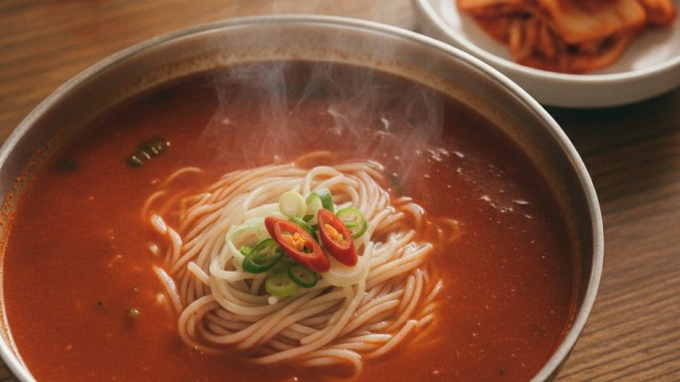 Bowl of Korean saengseon-guksu spicy freshwater fish noodle soup with red broth and thin wheat noodles — okcheon saengseon guksu