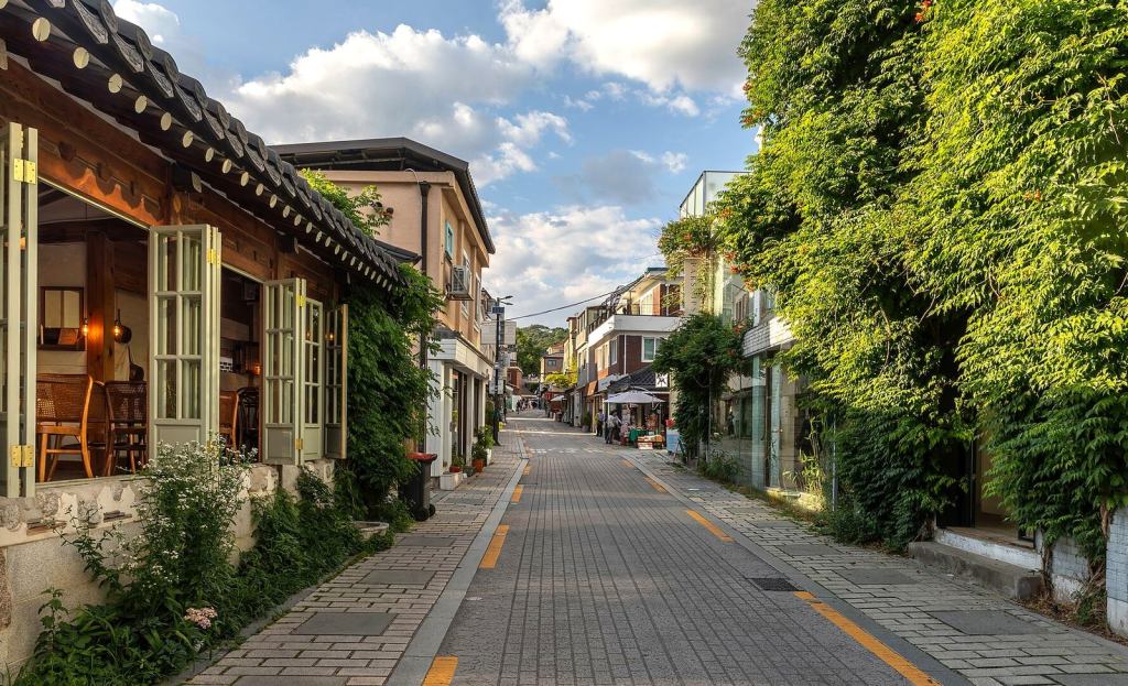 A picturesque hanok-lined cafe street in Seoul with greenery — korean coffee king