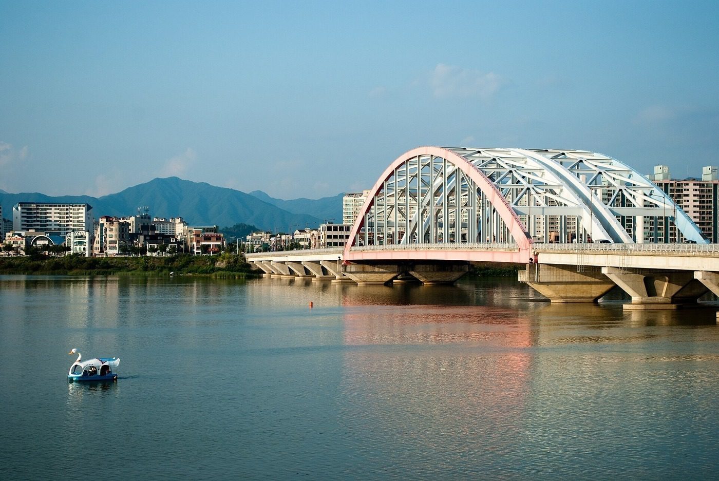 A pink arch bridge over a river in Chuncheon, Gangwon Province, South Korea — song kang military
