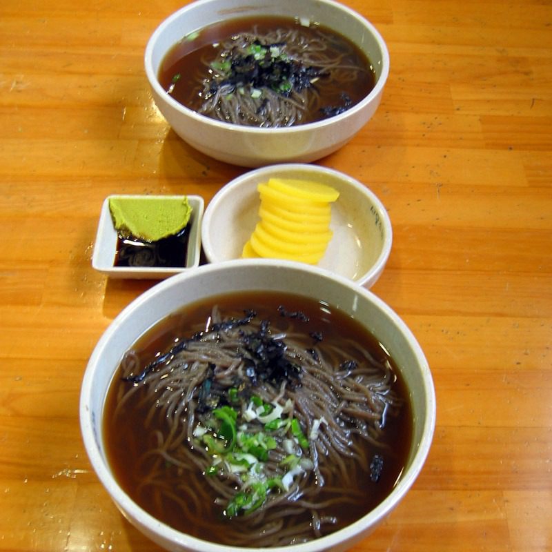 Bowl of memil guksu, Korean cold buckwheat noodles in broth — bts hangul typeface